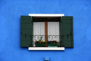 Spanish Curtains on colorful blue house 